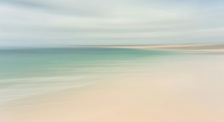 an empty sandy beach under an overcast sky