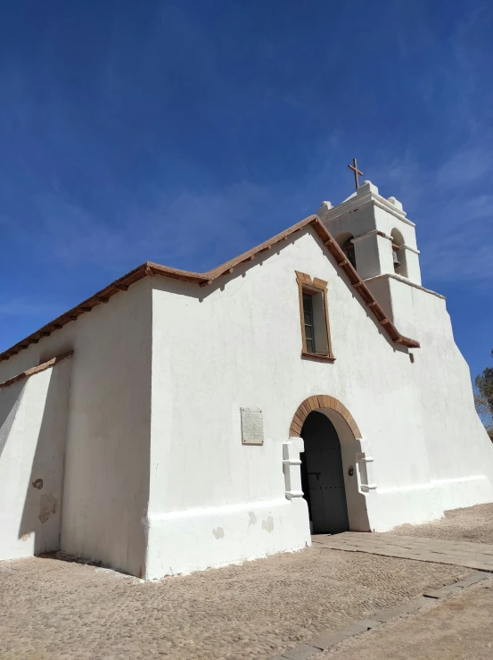 an old church with a steeple against a blue sky