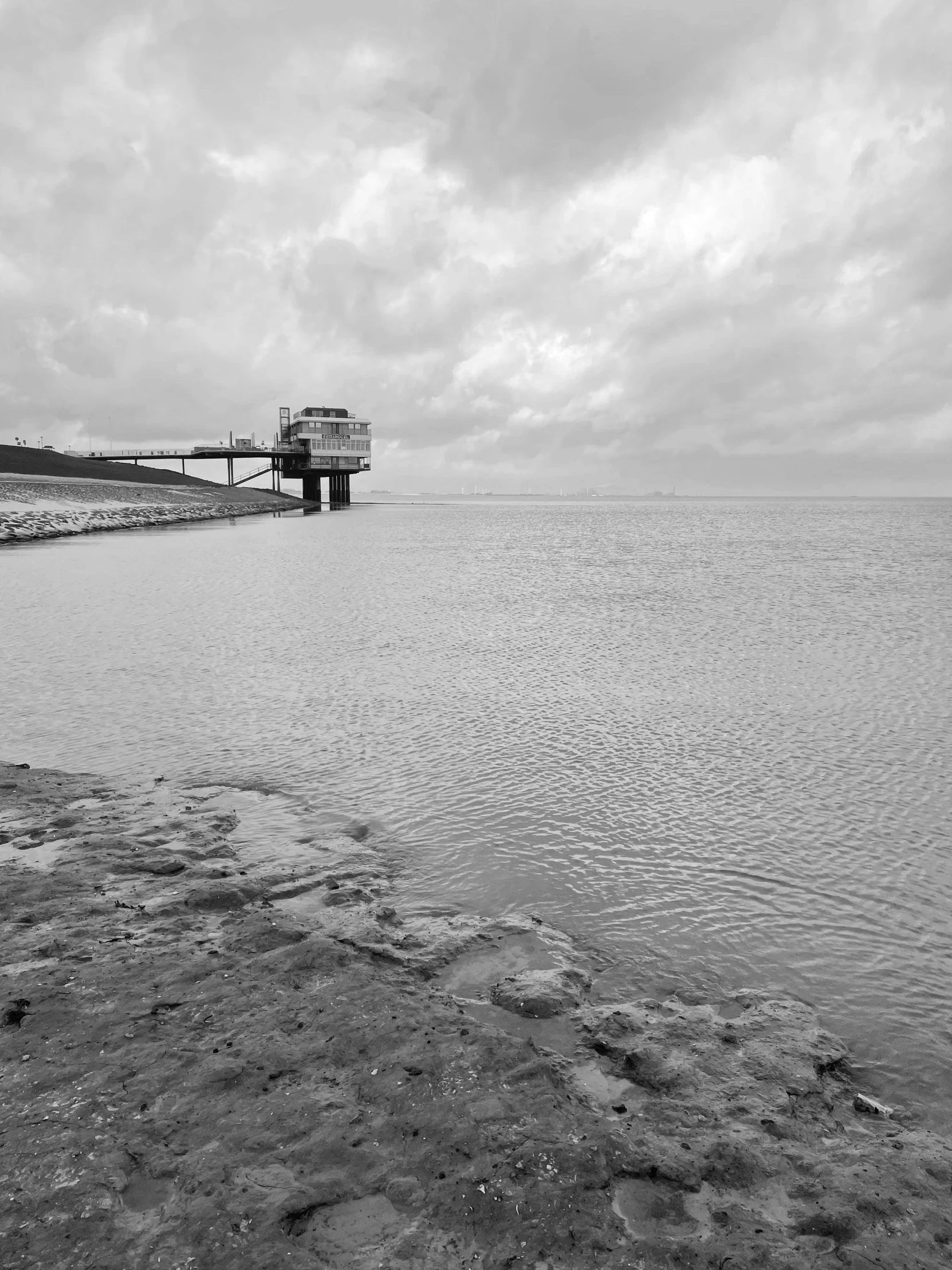 an ocean scene with a bridge and some water