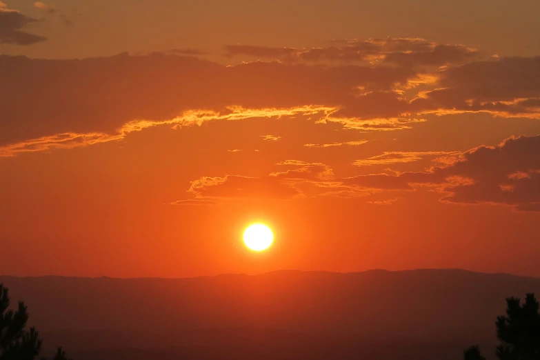 the sun is set behind some clouds on a sunny day