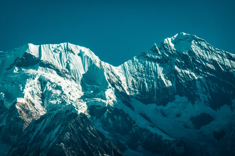 mountains covered in snow with a blue sky above