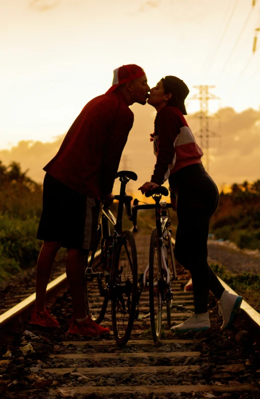 two people kissing near bikes on the tracks