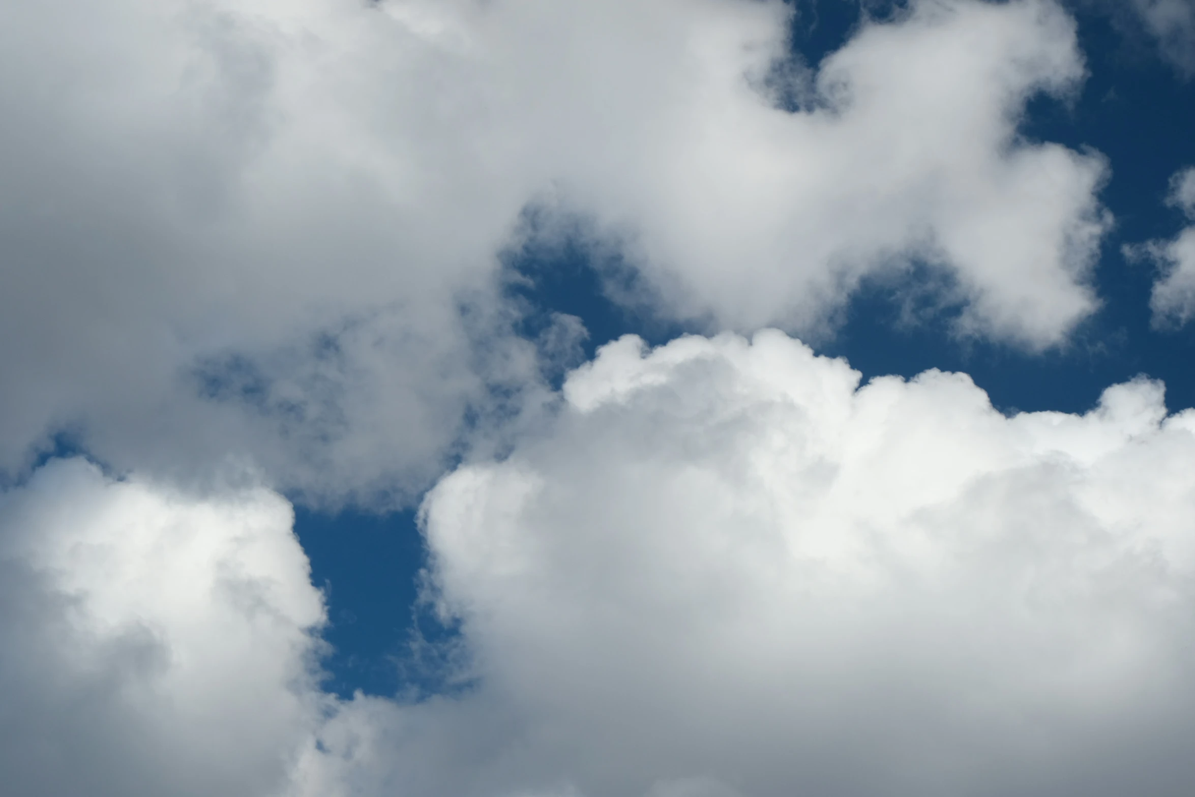 a plane is flying in a cloud covered sky