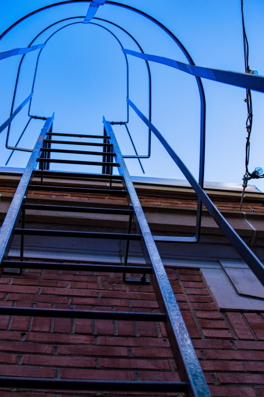 a metal ladder going up a brick wall