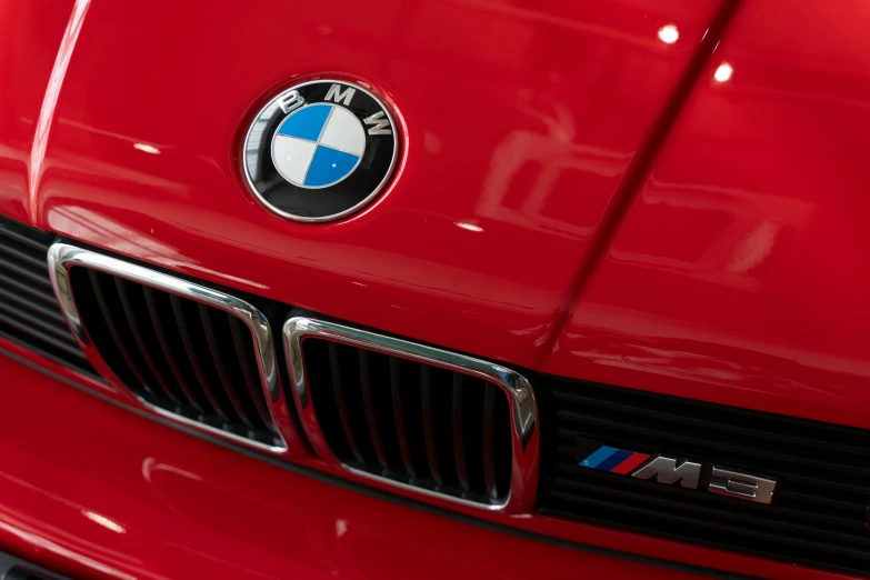 the front of a red bmw car with emblem on it