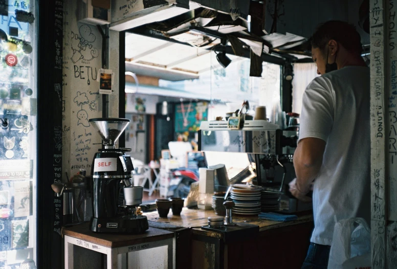 man standing at counter with plates and a pot on it