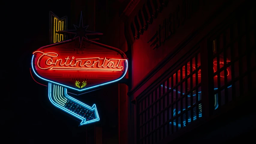 neon signage hanging from the side of a building