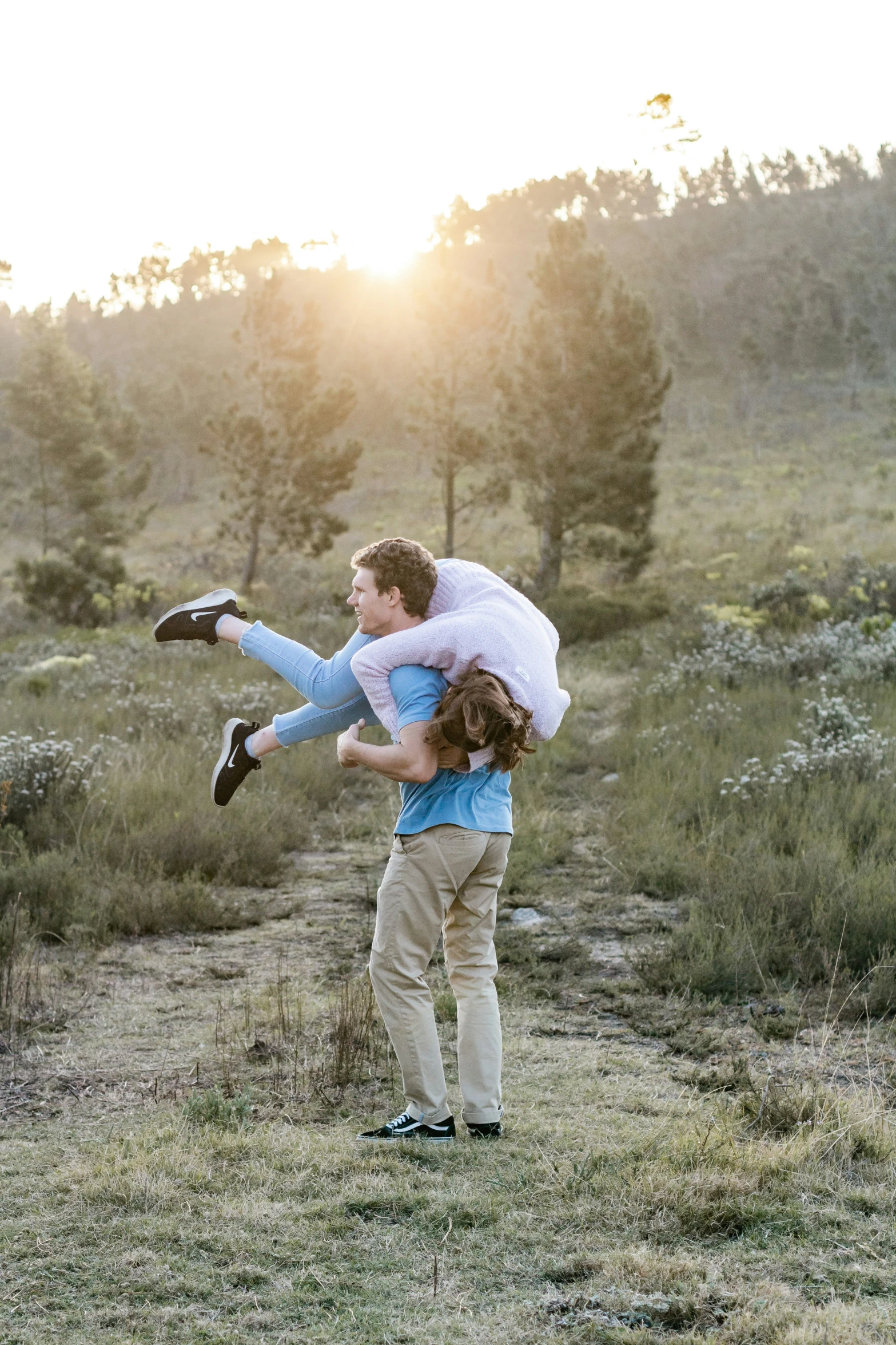 the girl is playing with the man outside in the field