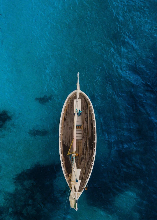 top view of a large boat sailing on a clear blue ocean