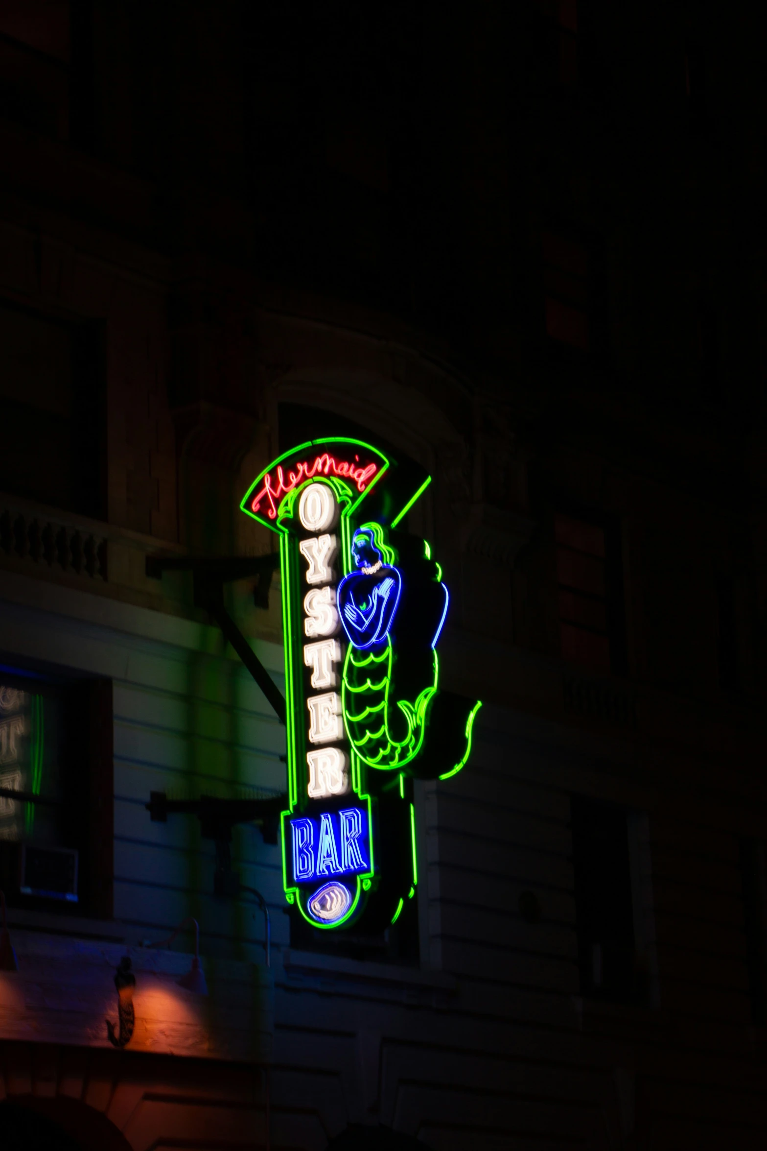 the neon sign on the building is very brightly lit
