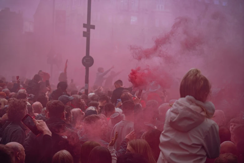 several people are walking around with colored smoke