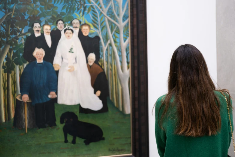 woman viewing painting in hallway with dog on grass