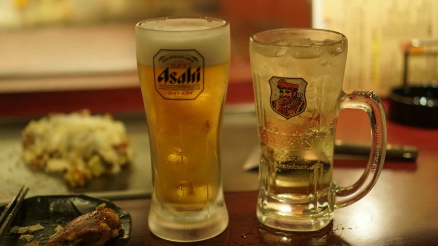 a beer glass is next to an iced mug