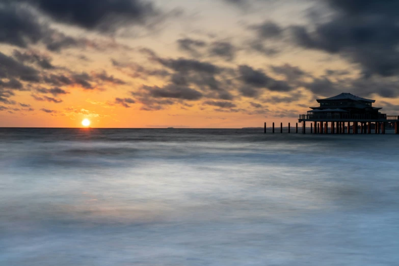 the sun is setting over the ocean and water