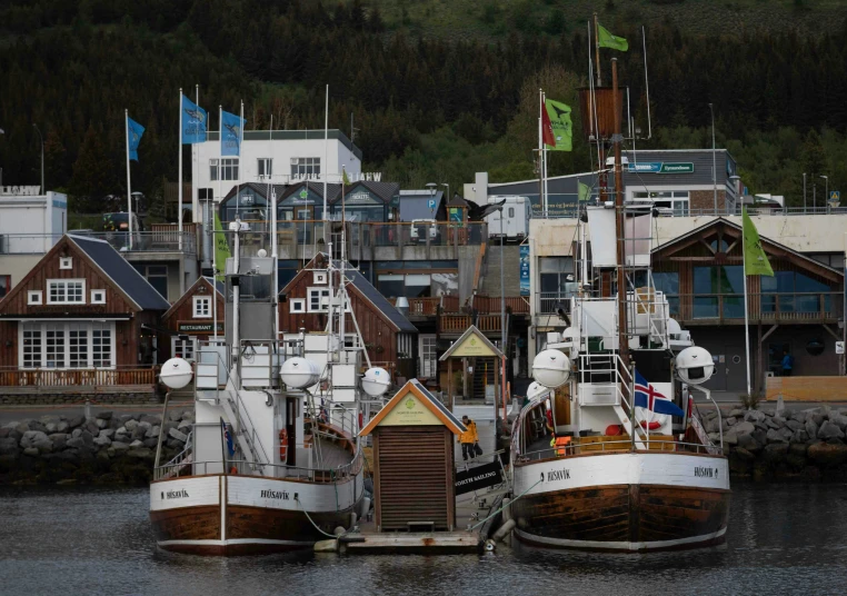 two boats parked near a harbor with mountains in the background