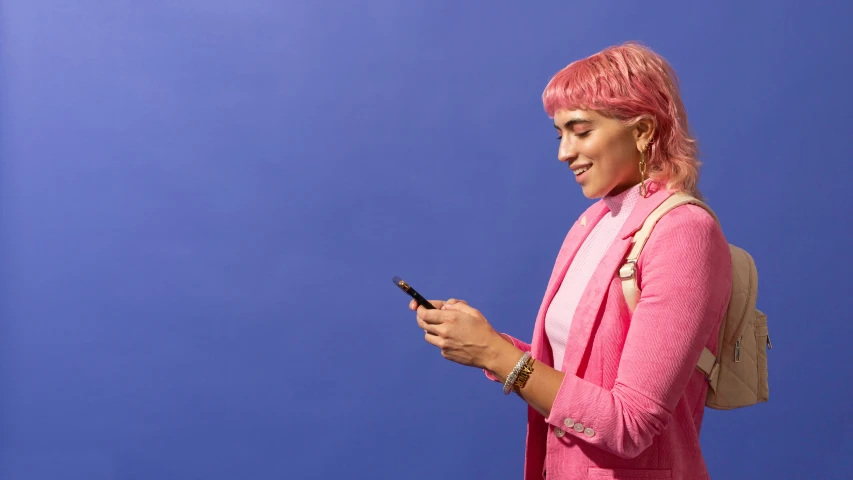 a woman with pink hair using her cell phone