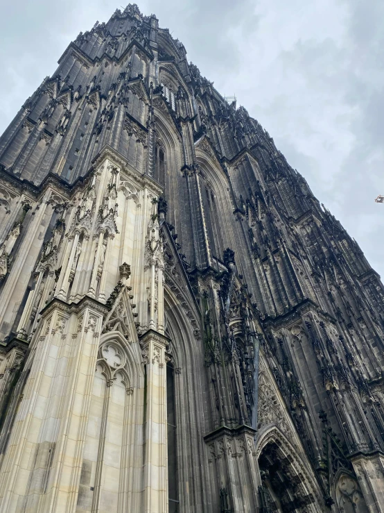 a large cathedral is standing tall and the sky is very cloudy