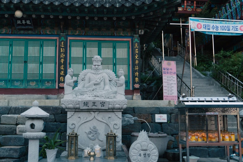 a statue is surrounded by two other asian statues