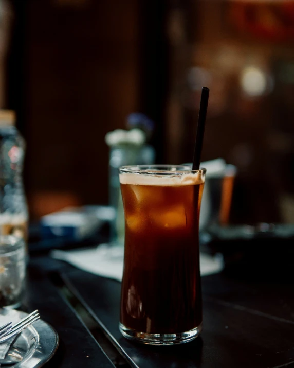 a drink in a tall glass sits on the bar