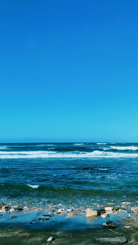 the view from shore of a vast ocean with blue sky