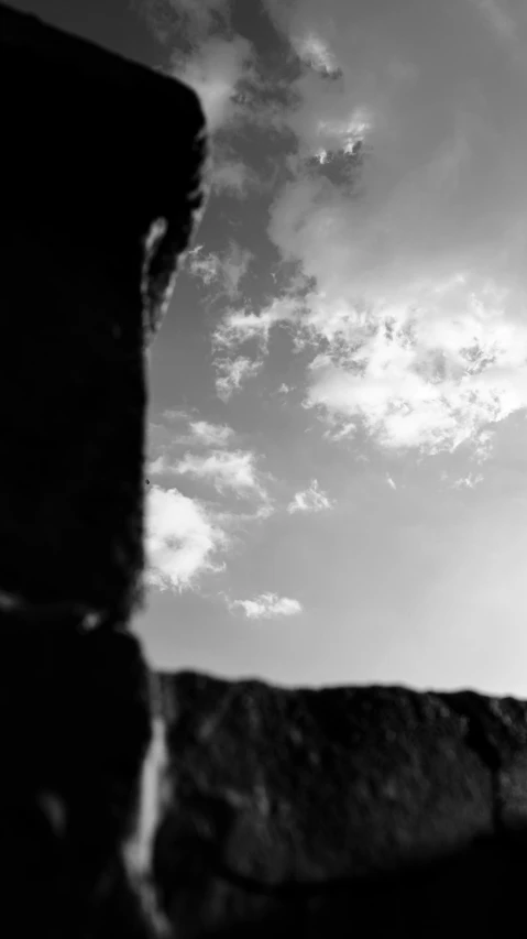 an airplane flying over a rocky cliff on a cloudy day