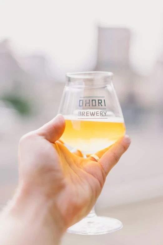 person holding a small glass with an oil in it