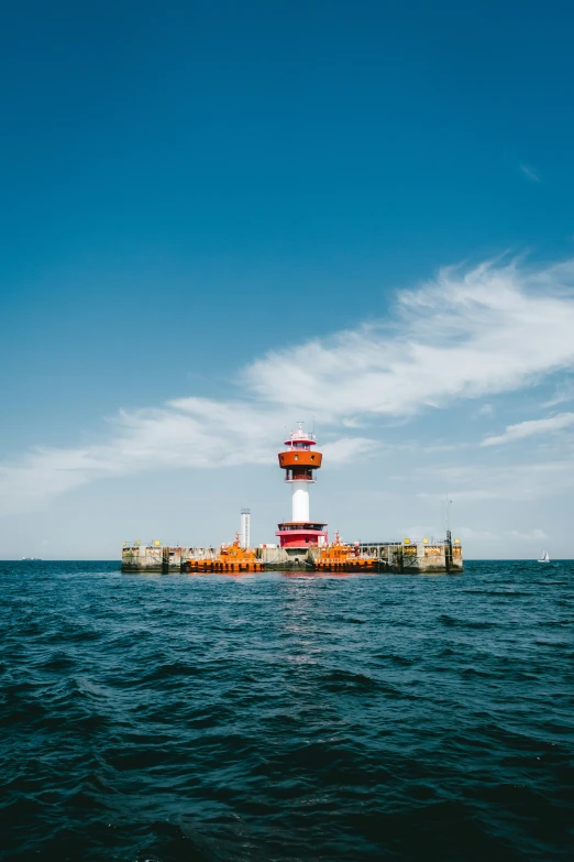 a light tower is sitting at the water's edge