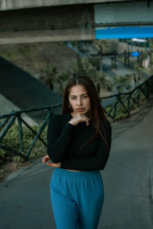 young woman in blue pants leaning on concrete bench