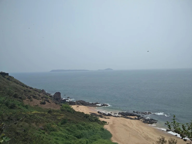 the beach near the edge of a large cliff