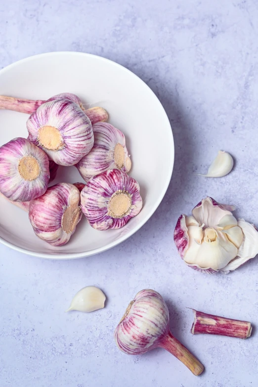 two white bowls full of different kind of garlic