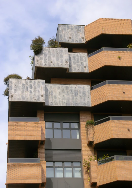 a tall brick building with a lot of plants growing on top of it