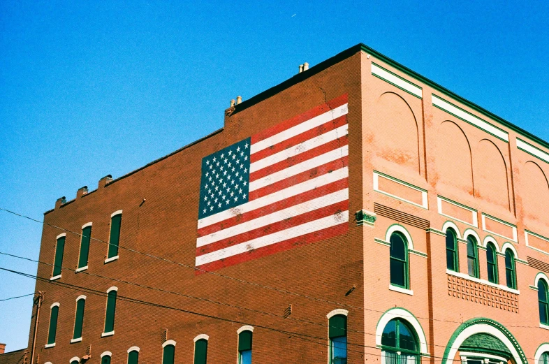 an old brick building with an american flag painted on it's side