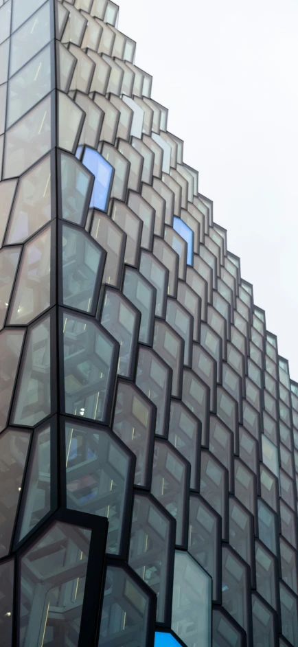 a large triangular shaped glass building with lots of windows on the side