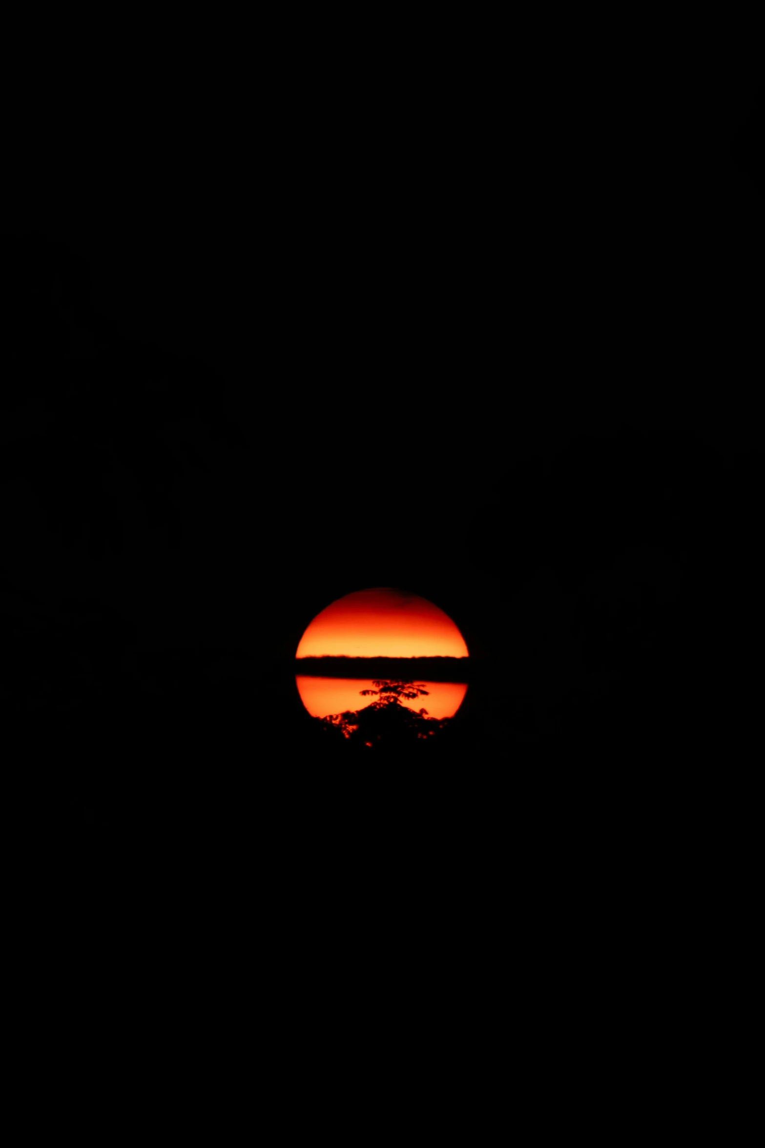 a large orange sunset on a black night