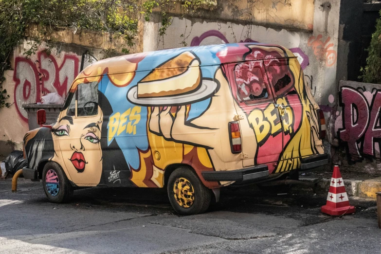 a van covered in a graffiti design is parked on the street