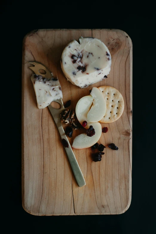 cheese is on a wooden board with a knife