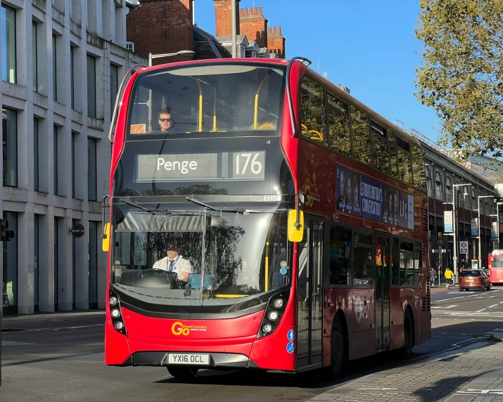 red double decker bus on street in city setting