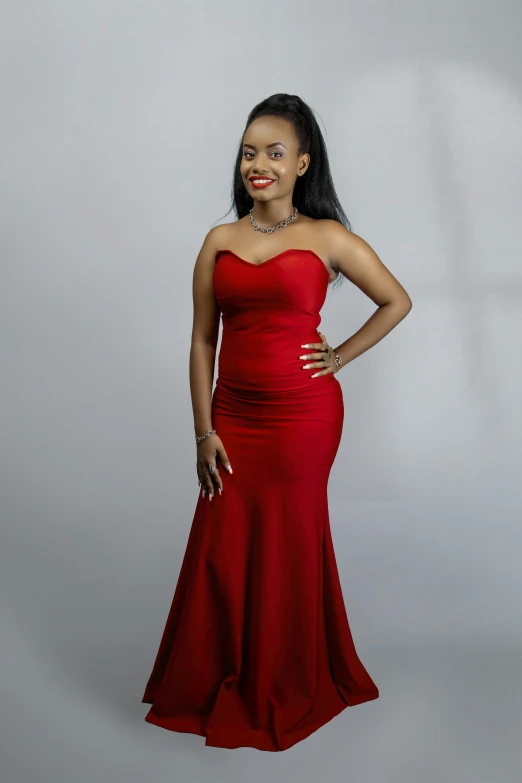 a beautiful young woman standing wearing a red dress