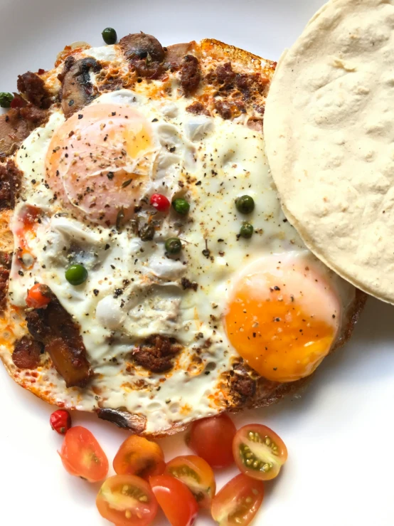 a plate with bread, fried eggs and a flatbread on it