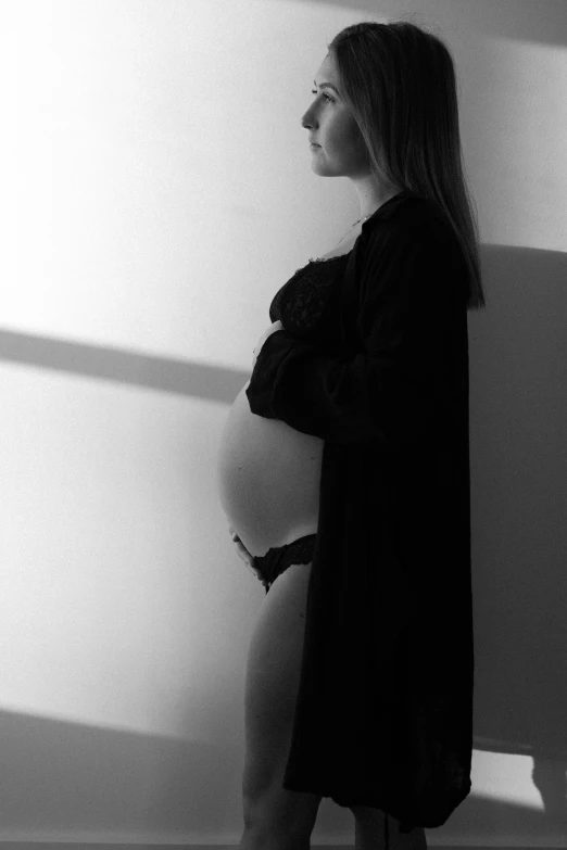 black and white pograph of a woman standing in the shadows