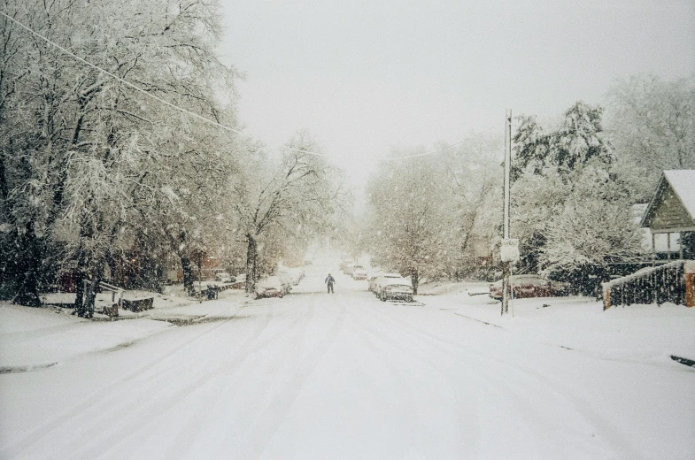 a view of a snowy road with people walking