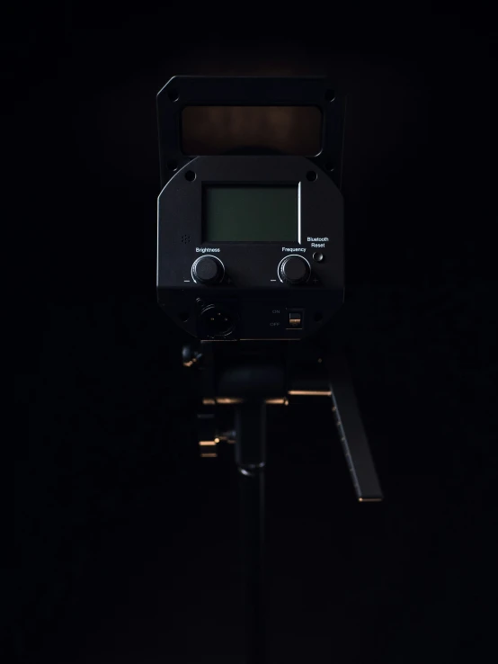 an old fashioned camera sits on the tripod in the dark