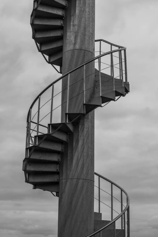 a spiral staircase against a cloudy sky