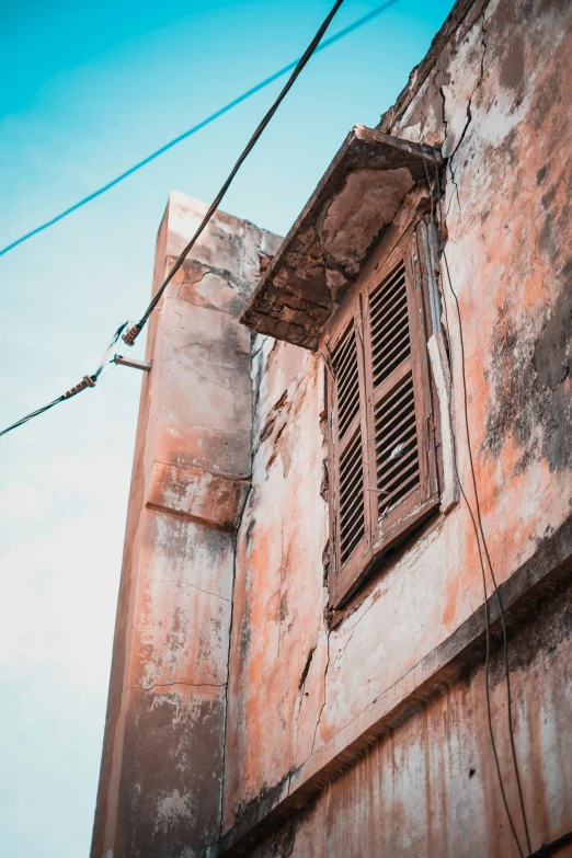 an old run down building with the bottom section of an outside window shutter open