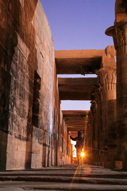 a person standing in a dark alley at sunset