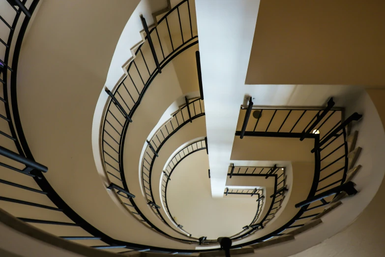 a very long and skinny spiral staircase in an office building