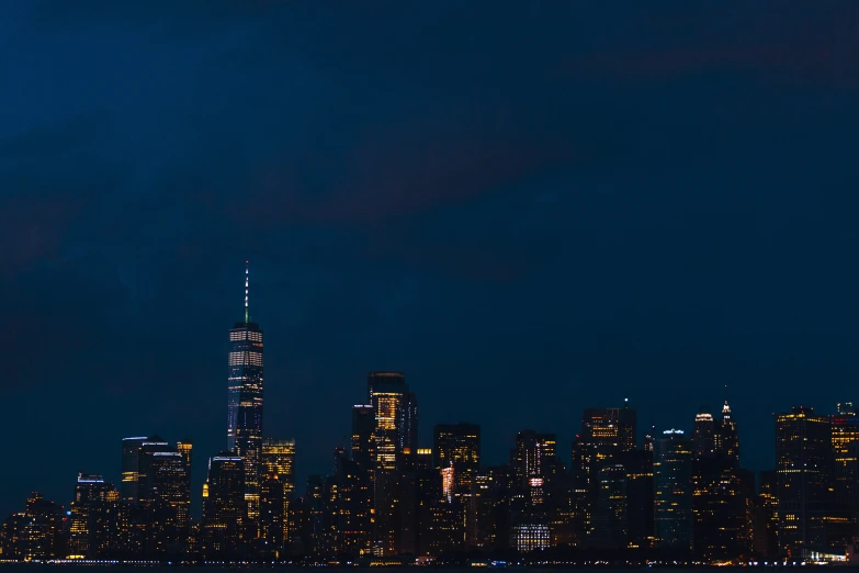 an airplane is flying over the water and a city at night