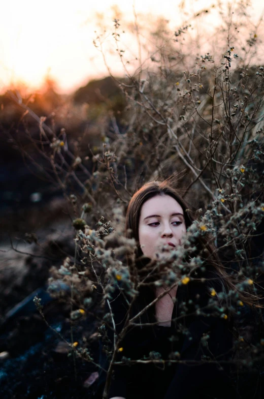 a young woman in the field is hiding her head among the flowers