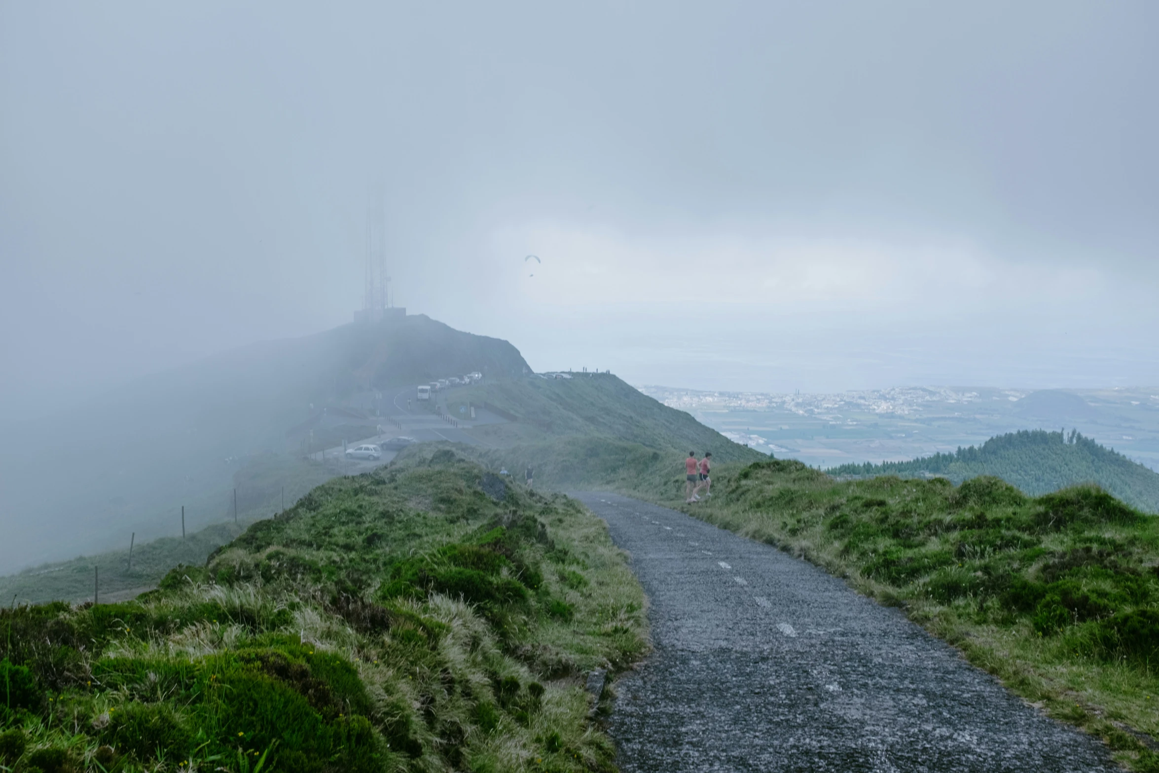 a foggy hill with a person walking up it