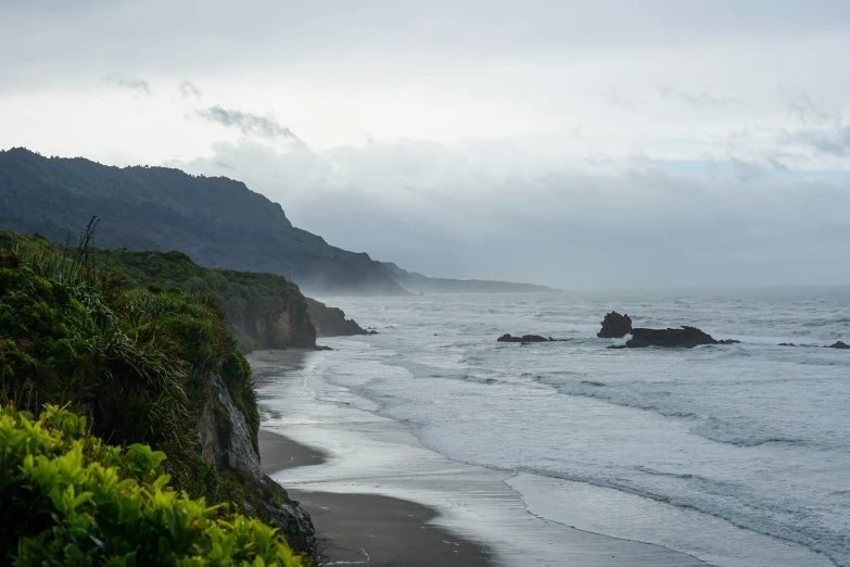 the beach near the ocean has waves crashing on the shore